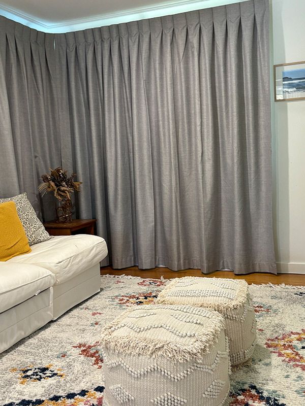 A Living Room With a Couch, Ottomans and Curtains — Artizen Curtains in Mooloolaba, QLD