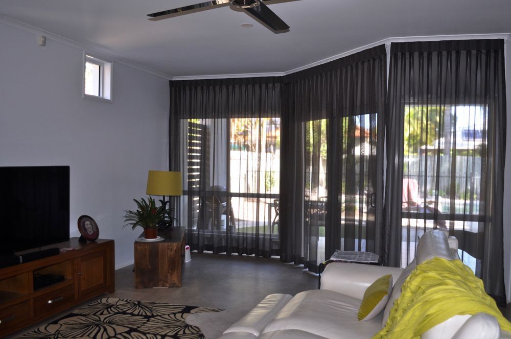 A Living Room With a Couch and a Flat Screen TV — Artizen Curtains in Mooloolaba, QLD