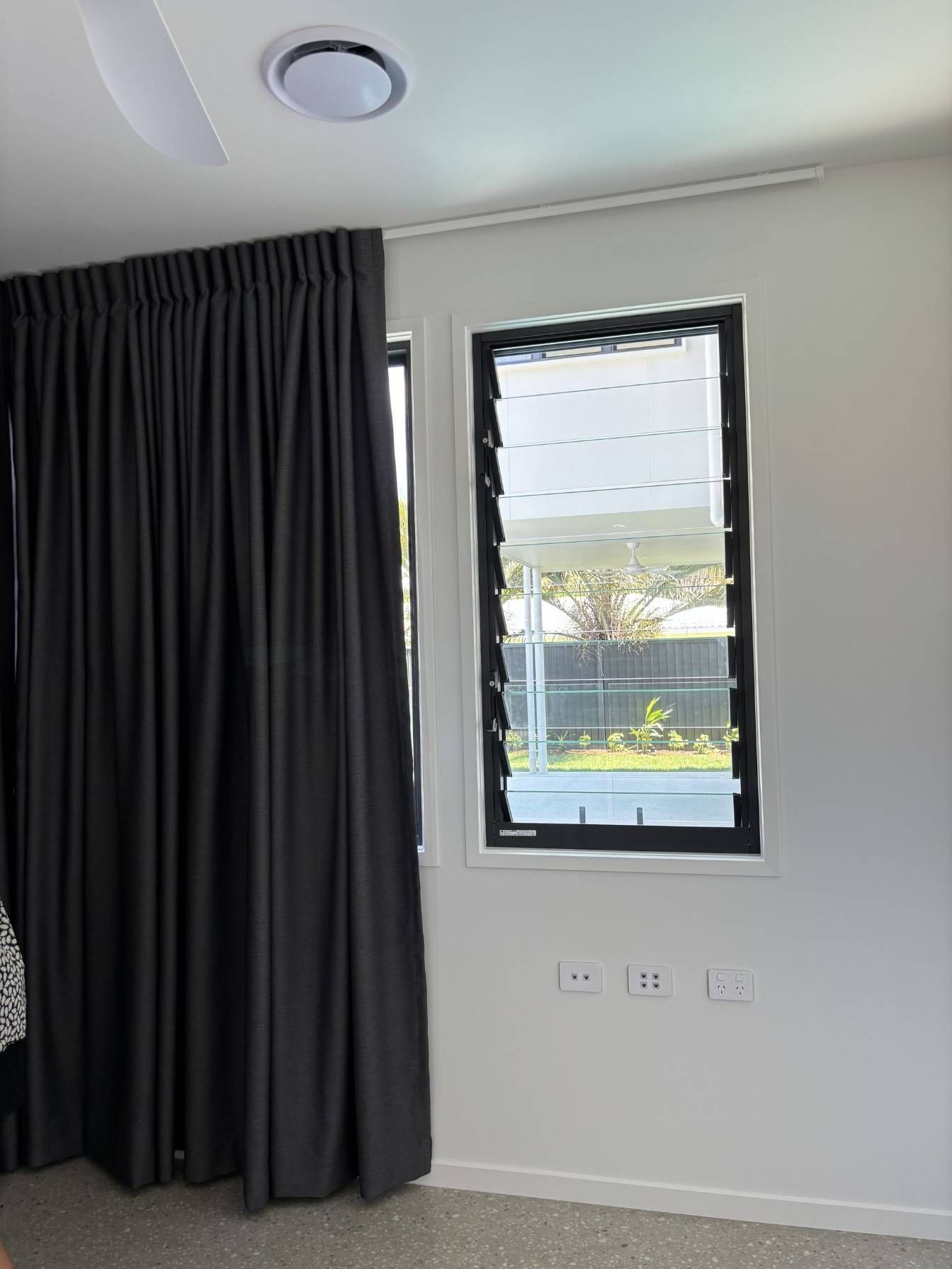 A Bedroom With a Large Window and Black Curtains — Artizen Curtains in Mooloolaba, QLD
