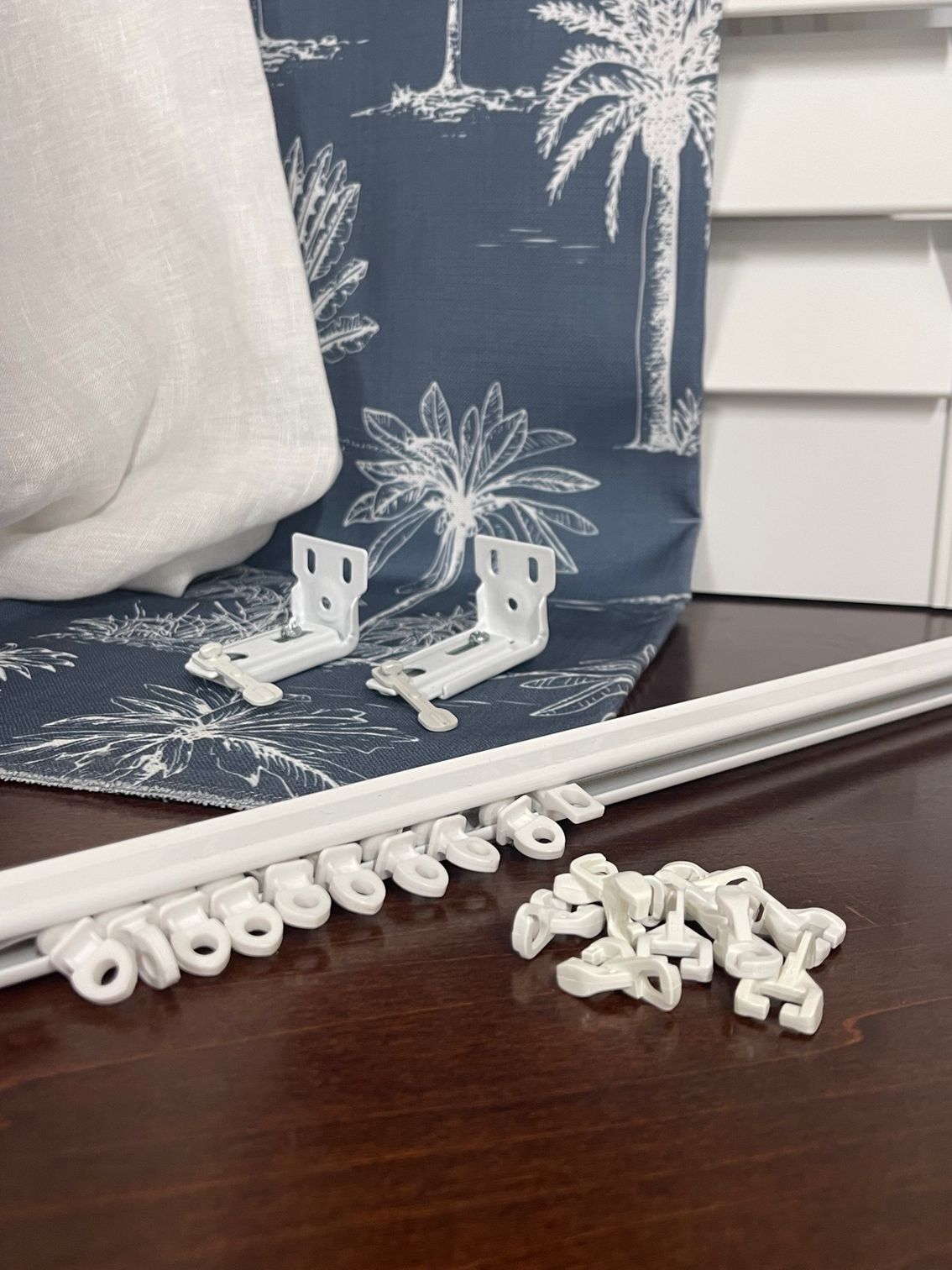 A Row Tracks on Floor with Blue Curtain Behind — Artizen Curtains in Mooloolaba, QLD