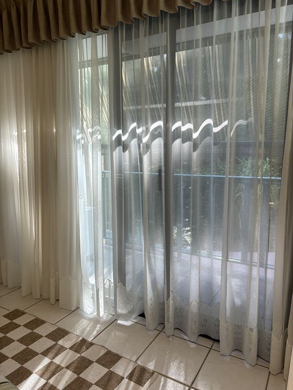 A Bedroom With Sliding Glass Doors and Black Curtains — Artizen Curtains in Mooloolaba, QLD