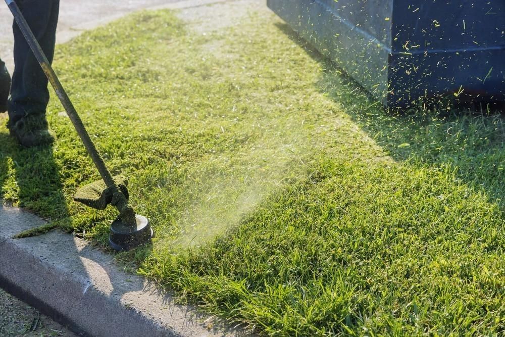 A man is using a lawn mower to cut the grass.