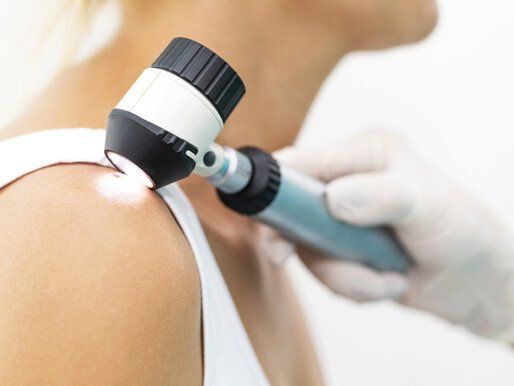A woman is getting her skin examined by a doctor