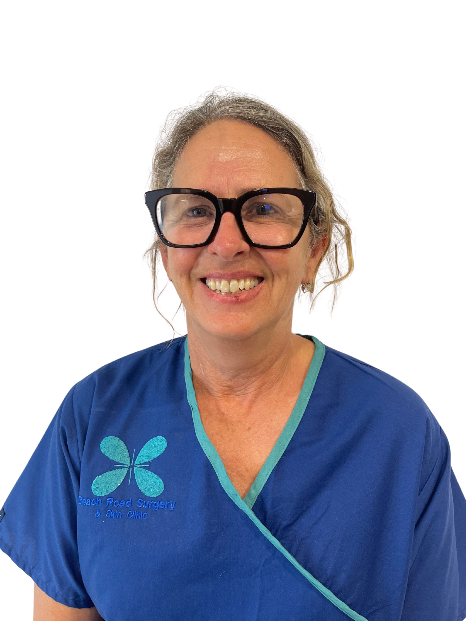 A woman wearing glasses and a blue scrub top is smiling.