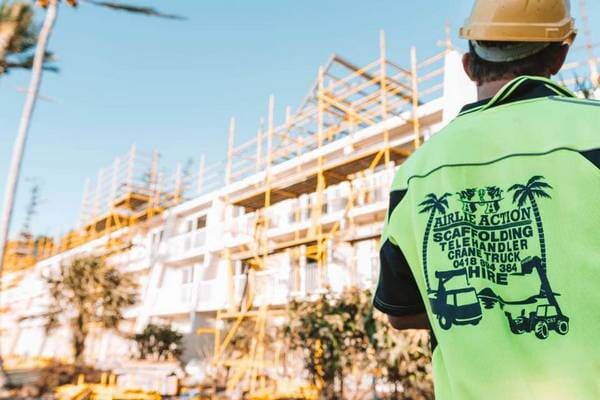 Tradie Standing In Front Of Scaffolding — Airlie Action Scaffolding gallery in Arlie Beach, QLD