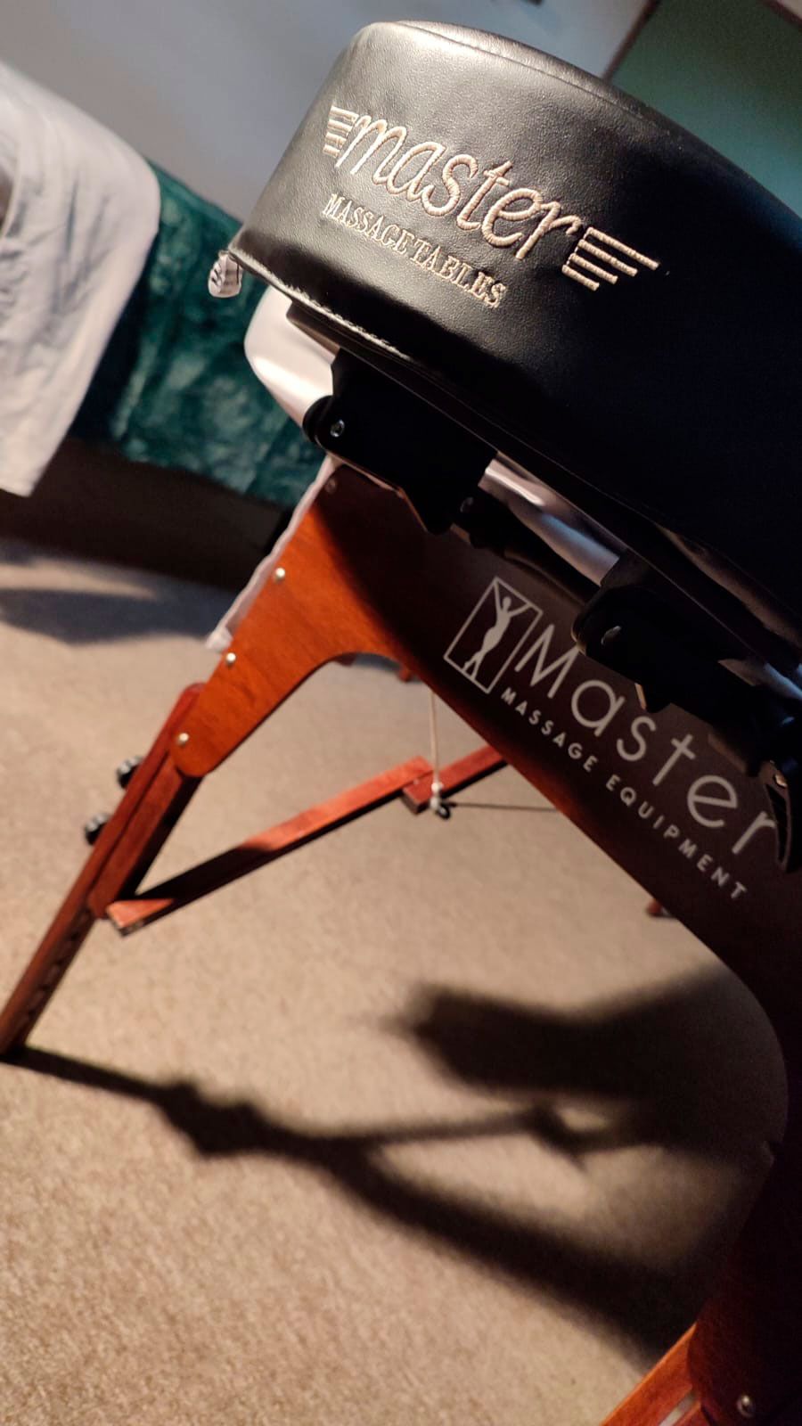 Una mesa de masaje maestra está sentada en el suelo en una habitación.