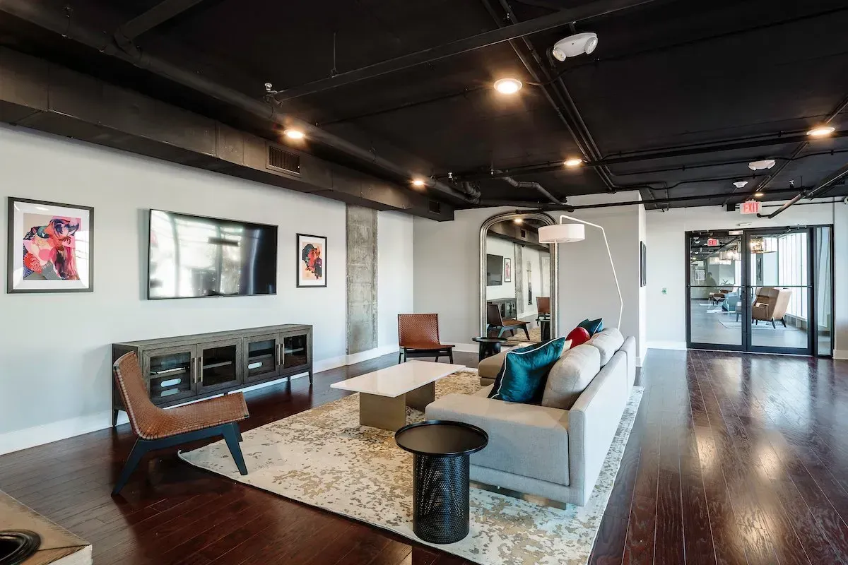 A living room with a couch , chairs , table and television.