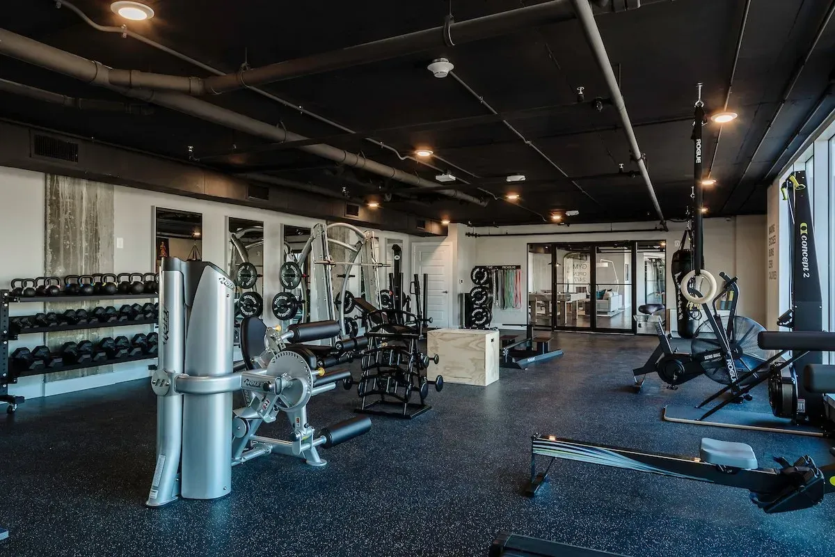 A large gym filled with lots of exercise equipment.