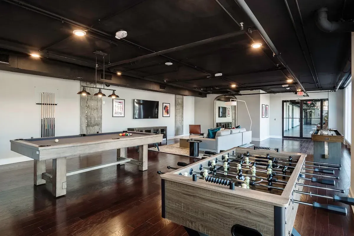 There is a pool table and a foosball table in the room.