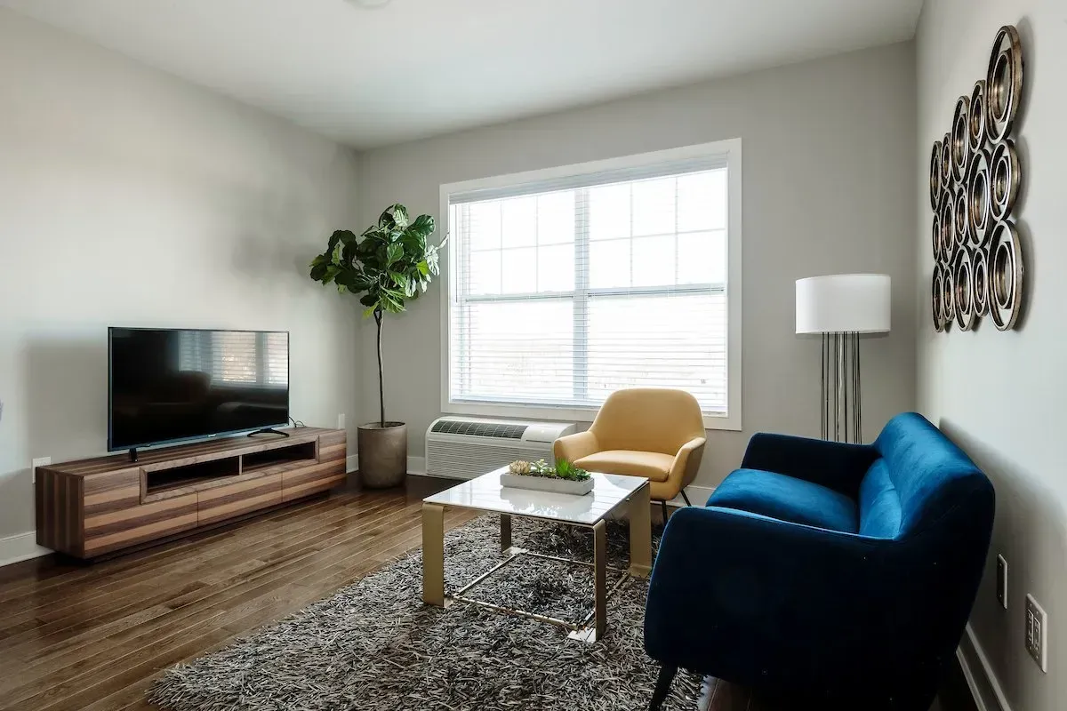 A living room with a blue couch and a yellow chair