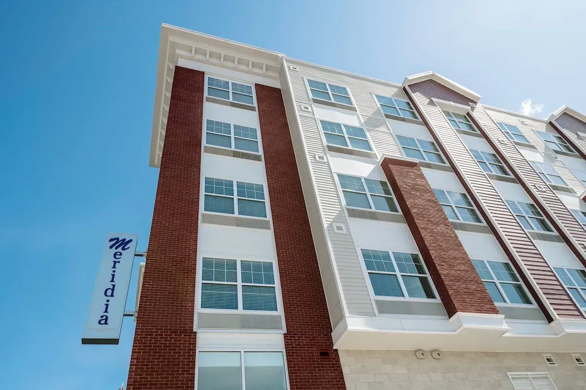 A large brick building with a lot of windows against a blue sky.