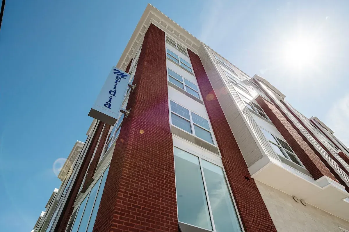 Looking up at a tall brick building with lots of windows