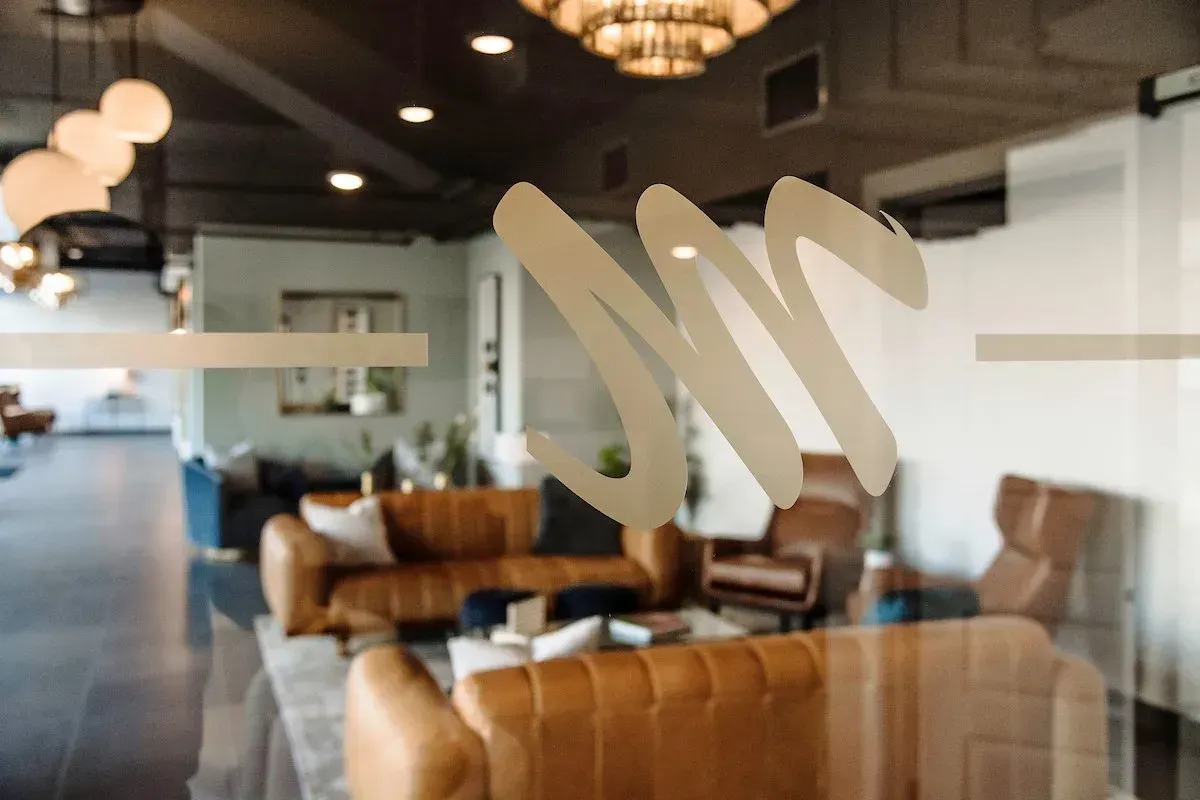 A living room with a couch , chairs , and a chandelier.