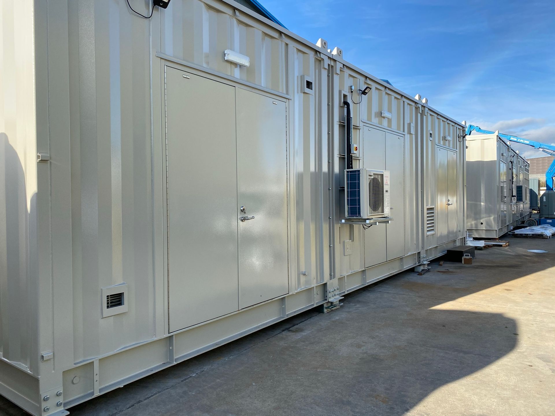 A brick building with green doors and a roof