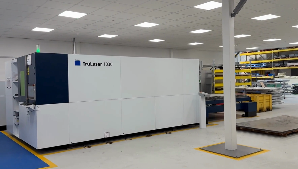 A large machine is sitting in a large room in a factory.