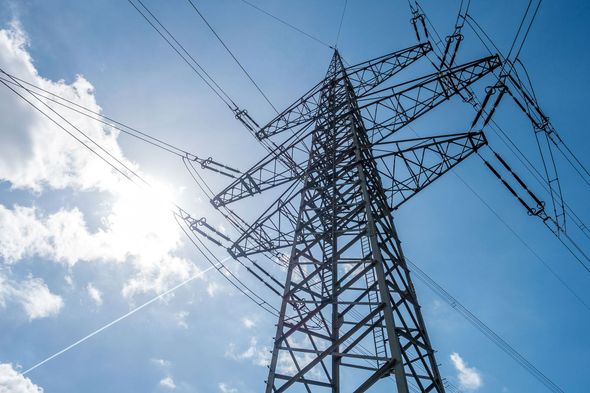 The sun is shining through the power lines on a sunny day.