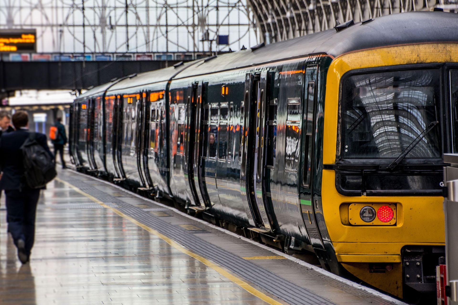 A man is walking towards a train at a train station.