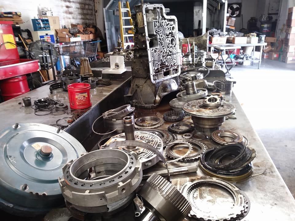 A bunch of parts are sitting on a table in a garage.