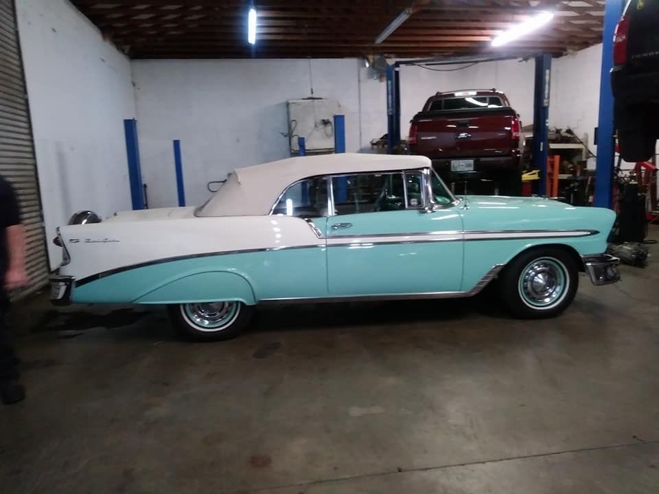 A blue and white car is parked in a garage