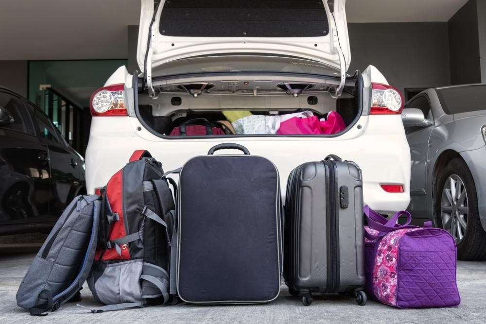 The trunk of a car is filled with luggage and backpacks — Whitsunday Transfer Service In Conway Beach, QLD