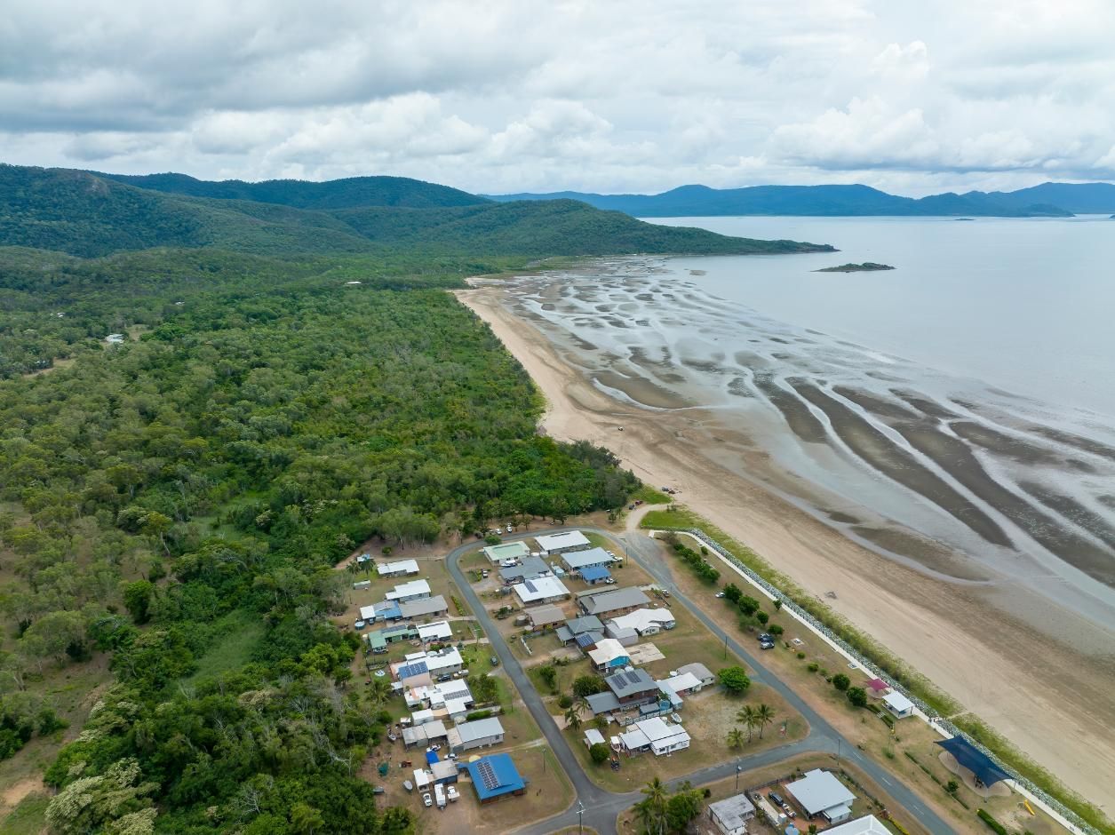An Aerial View Of A Beach Surrounded By Trees And A Body Of Water — Whitsunday Transfer Service In Conway Beach, QLD