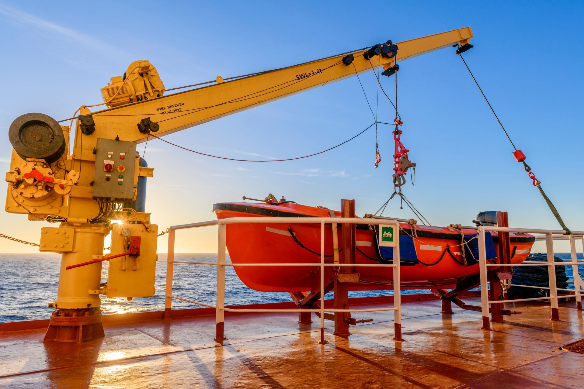 Crane lifting Lifeboat onboard Ship deck