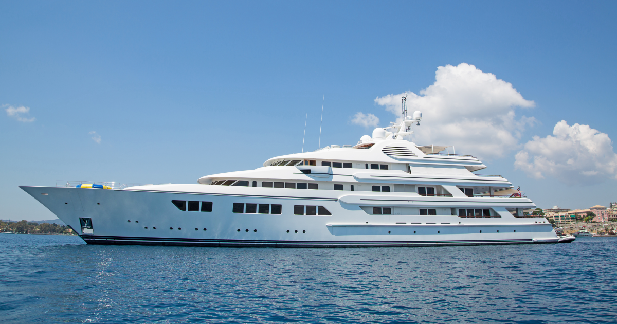 A large white yacht is floating on top of a body of water.