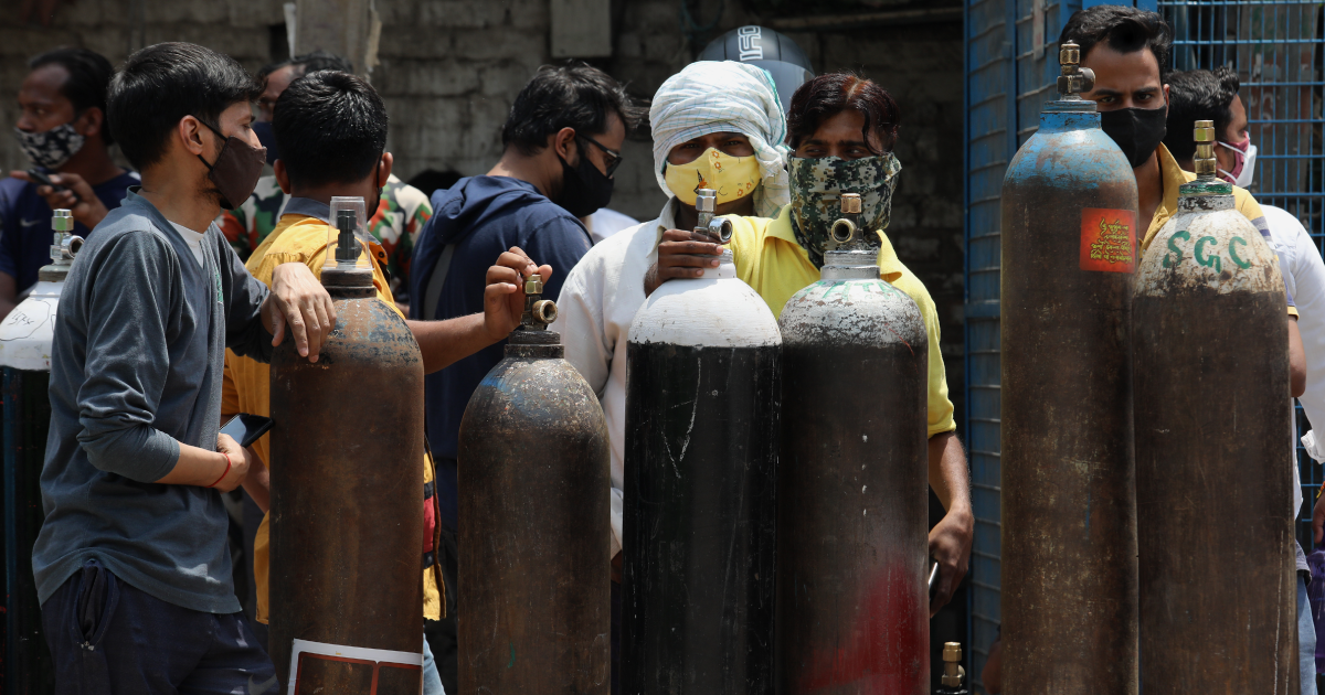 New Delhi, India, April 30, 2021: People stand in queue for refilling empty oxygen cylinders outside refilling center.