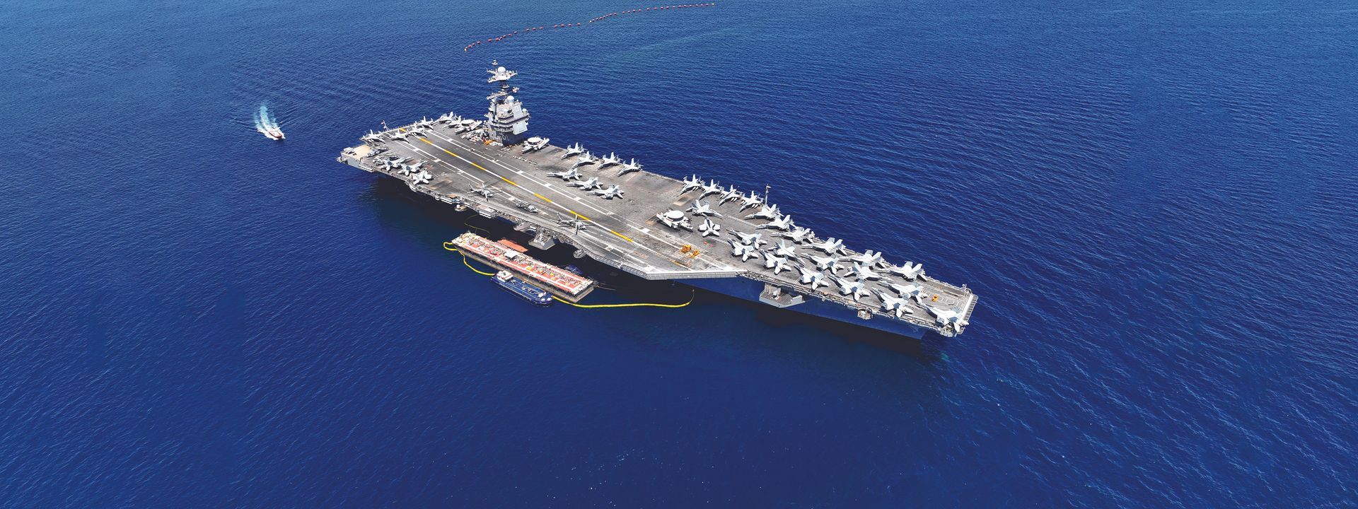 A large military ship is floating on top of a large body of water.