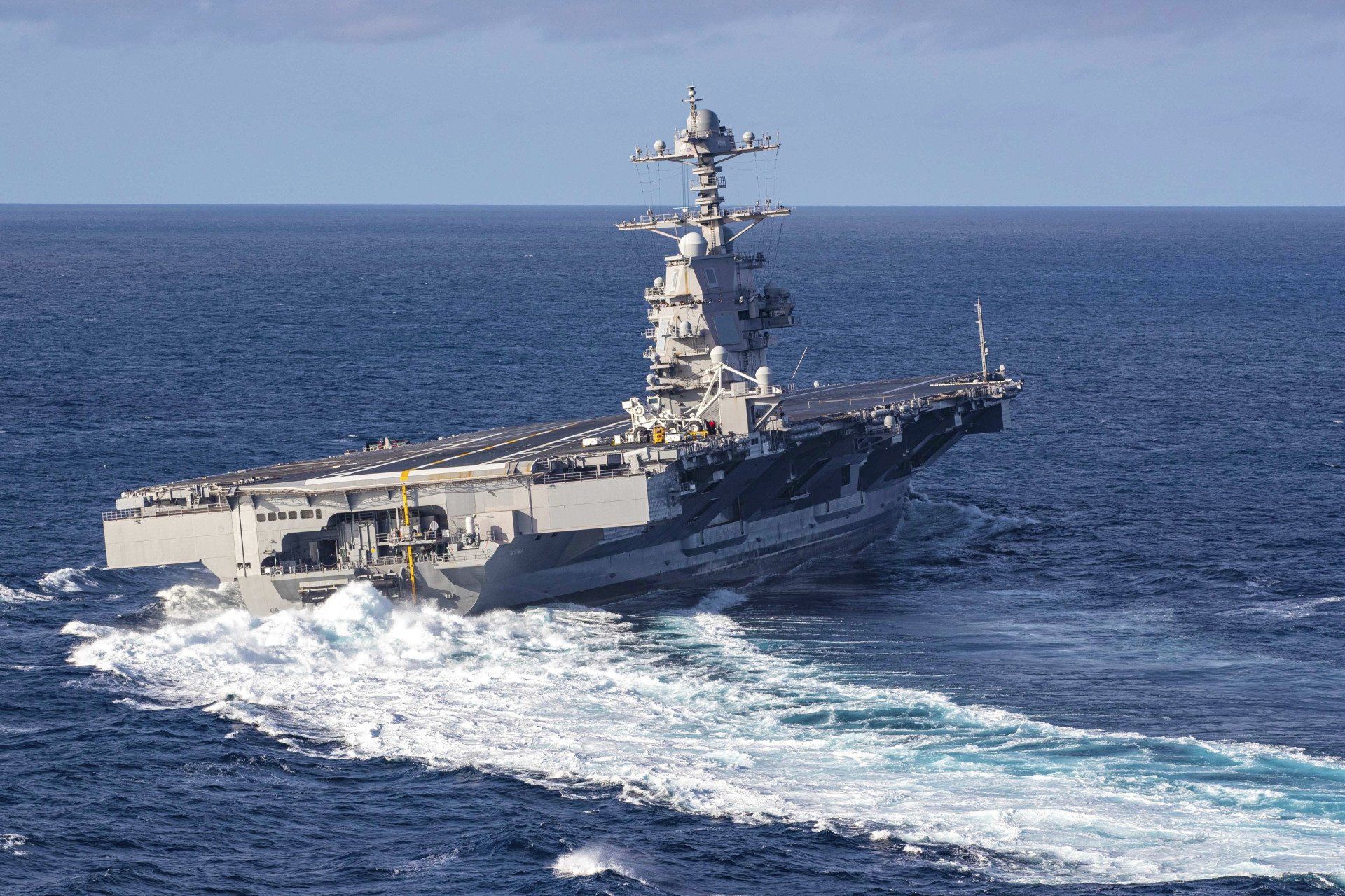 A large military ship is floating on top of a large body of water.