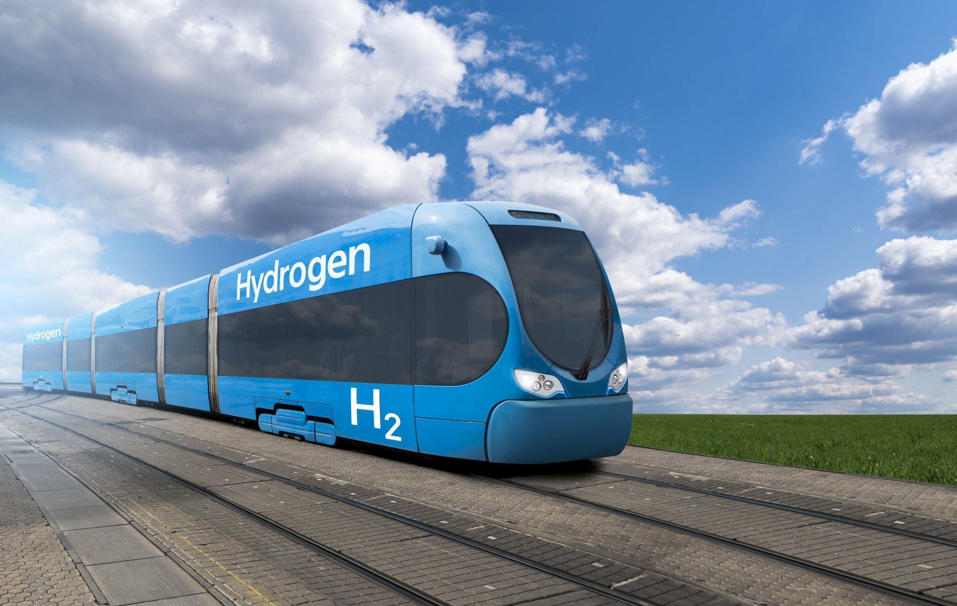 A blue hydrogen train is going down the tracks.