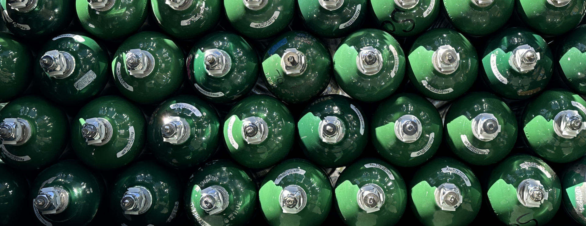 Photograph of stacked green oxygen cylinder tanks