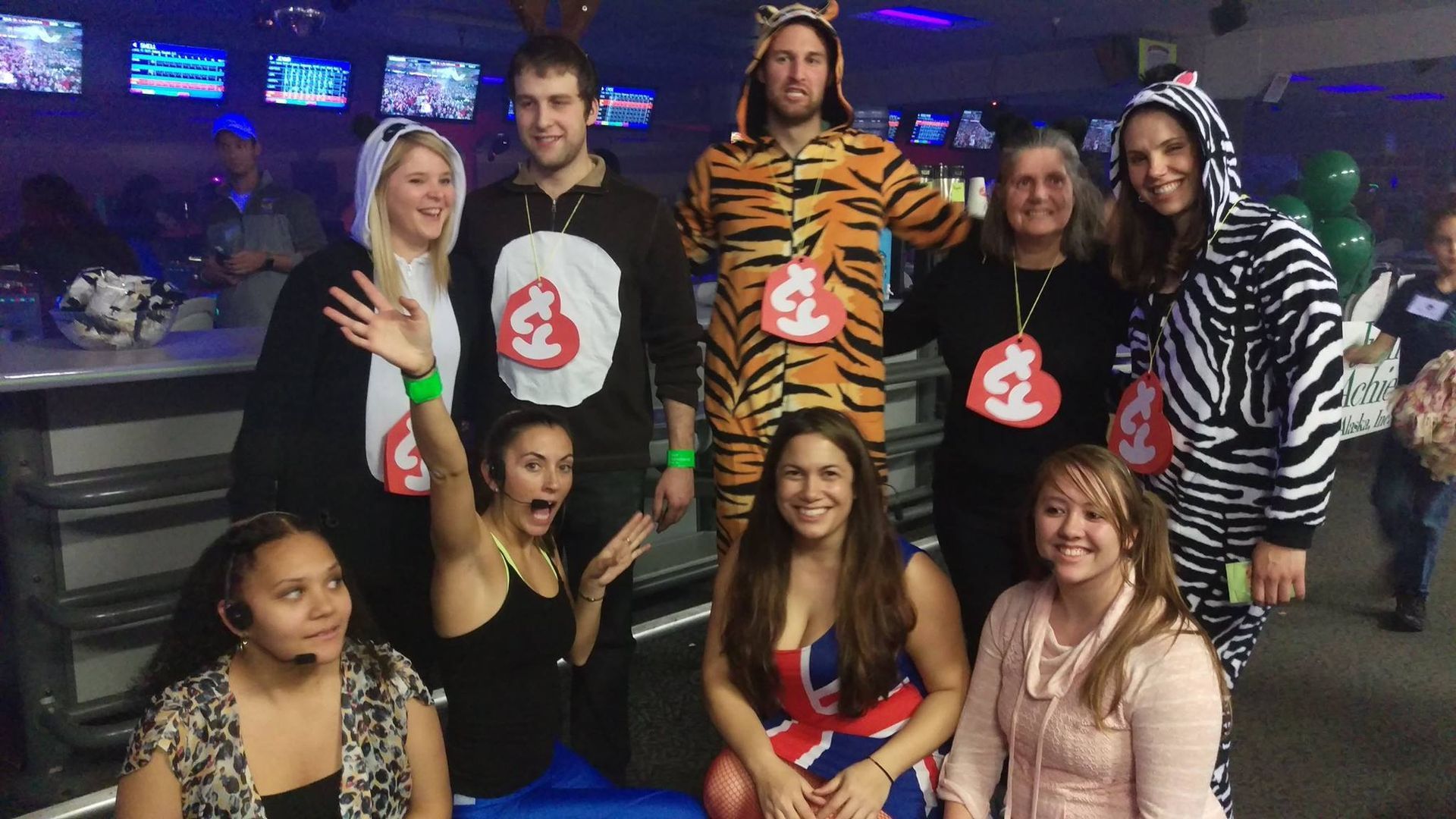 A group of young people are holding bowling balls in a bowling alley.