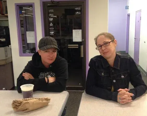 Two people are sitting at a table with a cup of coffee Two people are sitting at a table with a cup of coffee
