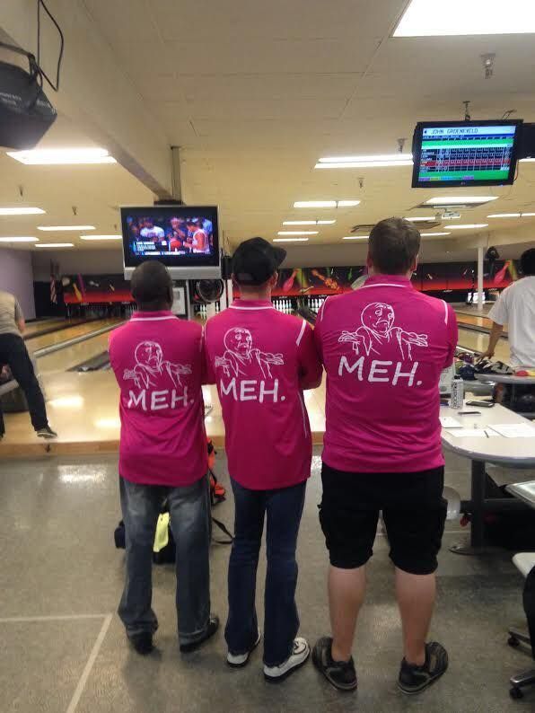 A group of young people are holding bowling balls in a bowling alley.