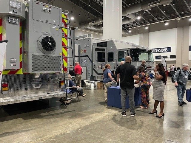 A group of people are standing in front of a large fire truck.