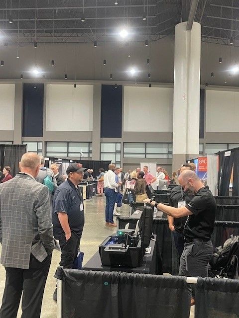 A group of people are standing in a large room talking to each other.