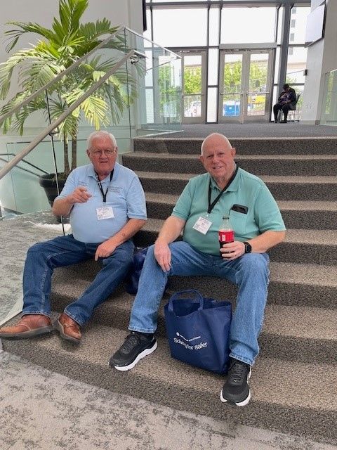 Two men are sitting on the steps of a building.