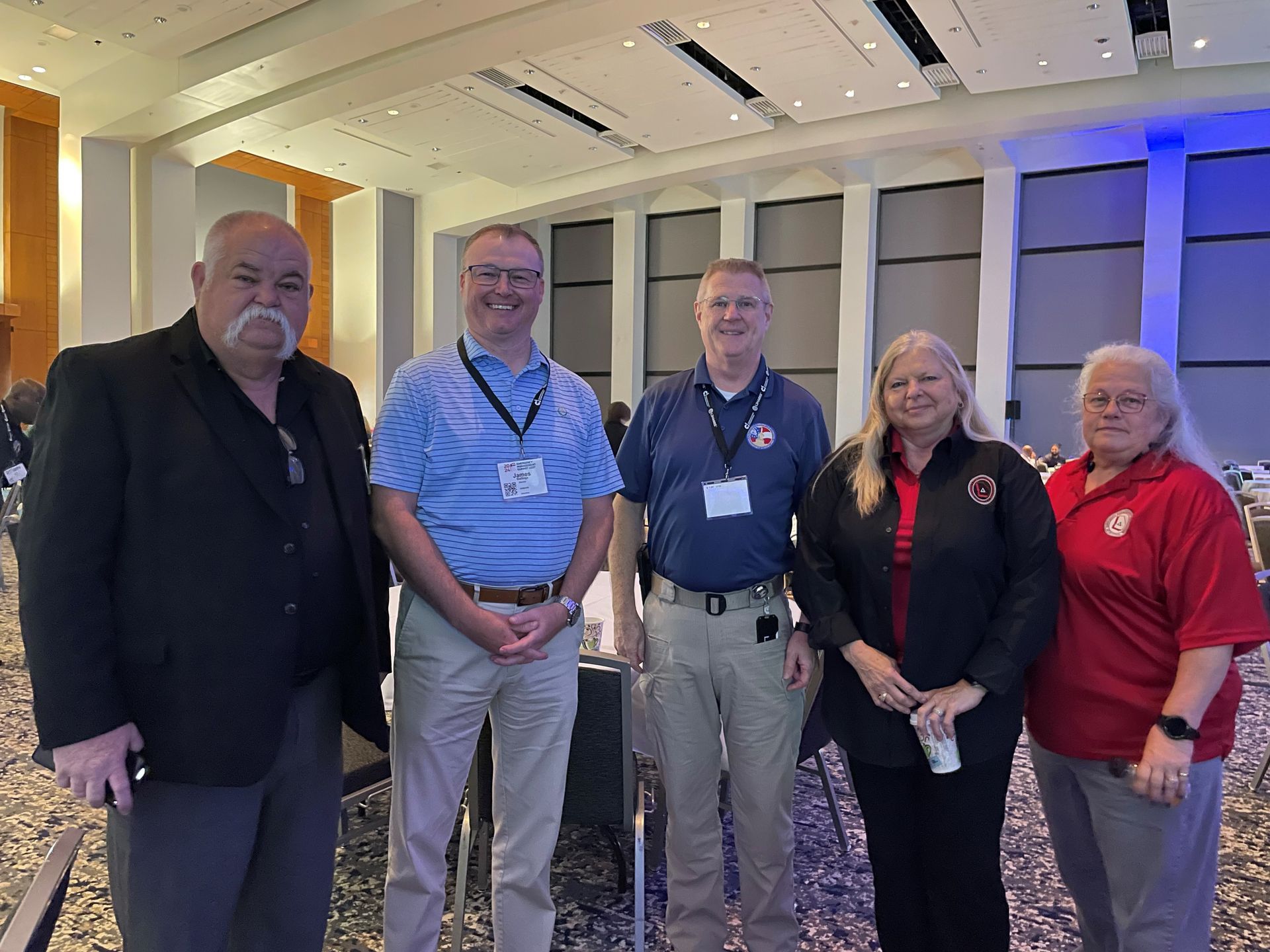 A group of people posing for a picture in a large room