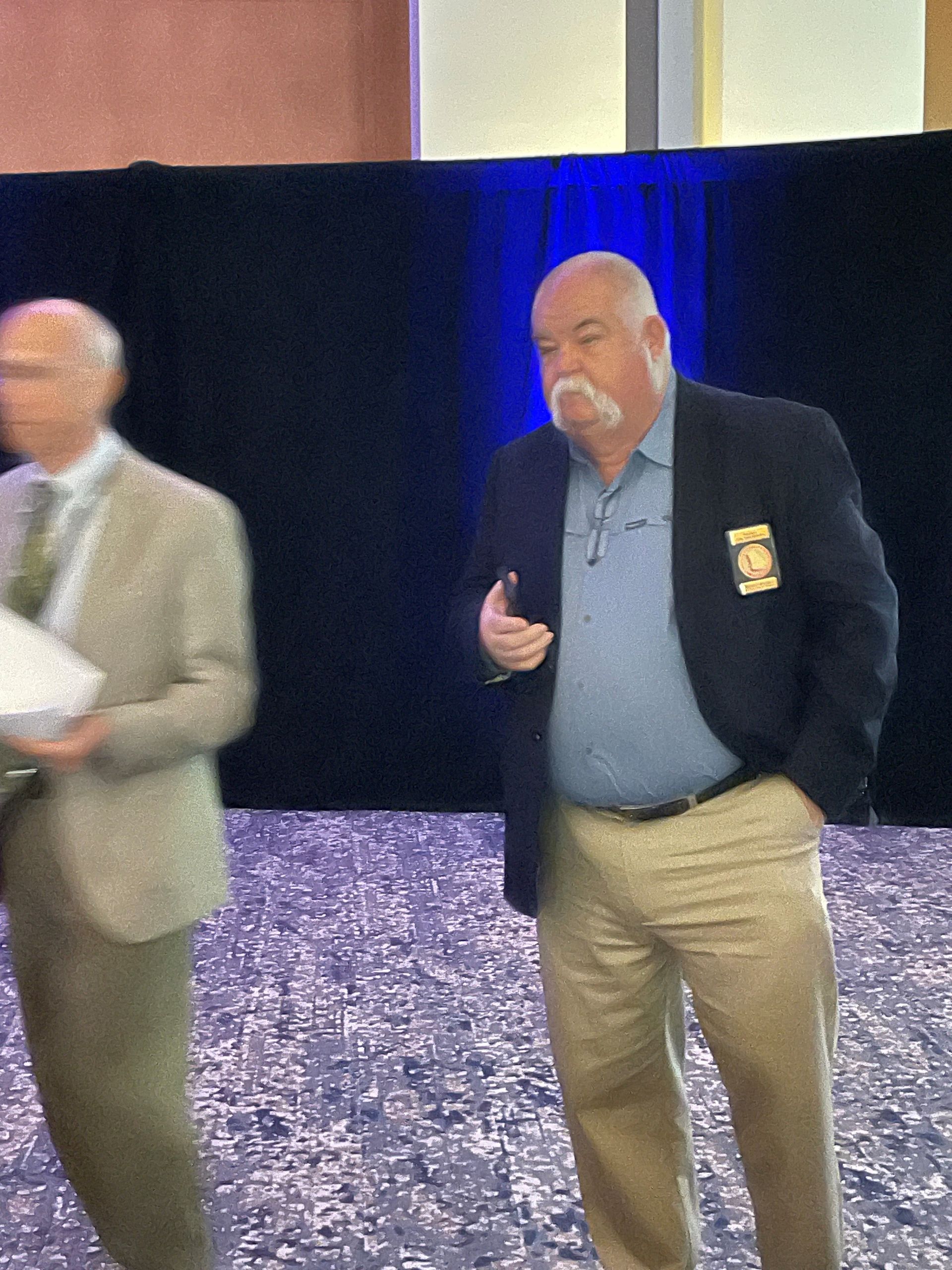 A man in a suit has a patch on his jacket