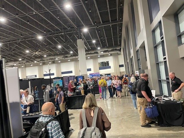 A group of people are standing in a large room.
