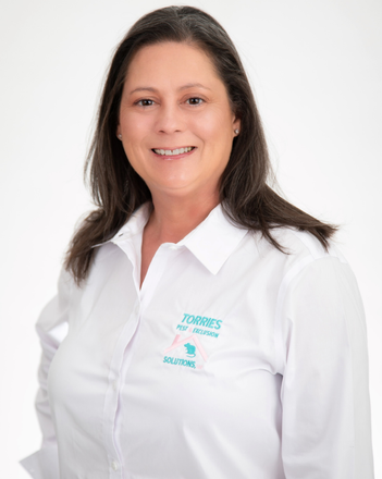 Woman in a white button-down shirt smiles at the camera; logo on shirt.