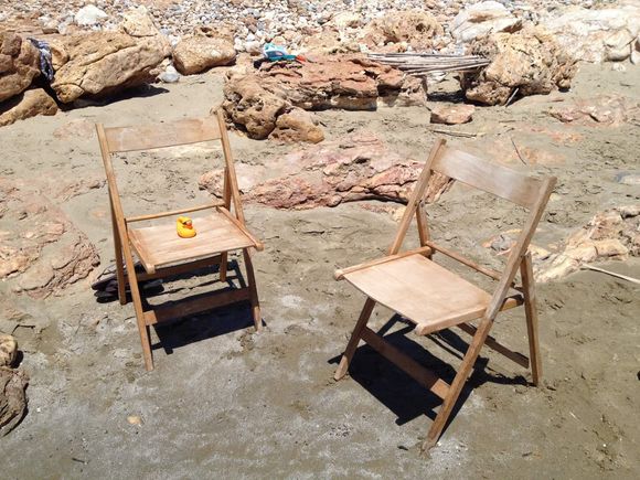 Delle sedie di legno in una spiaggia