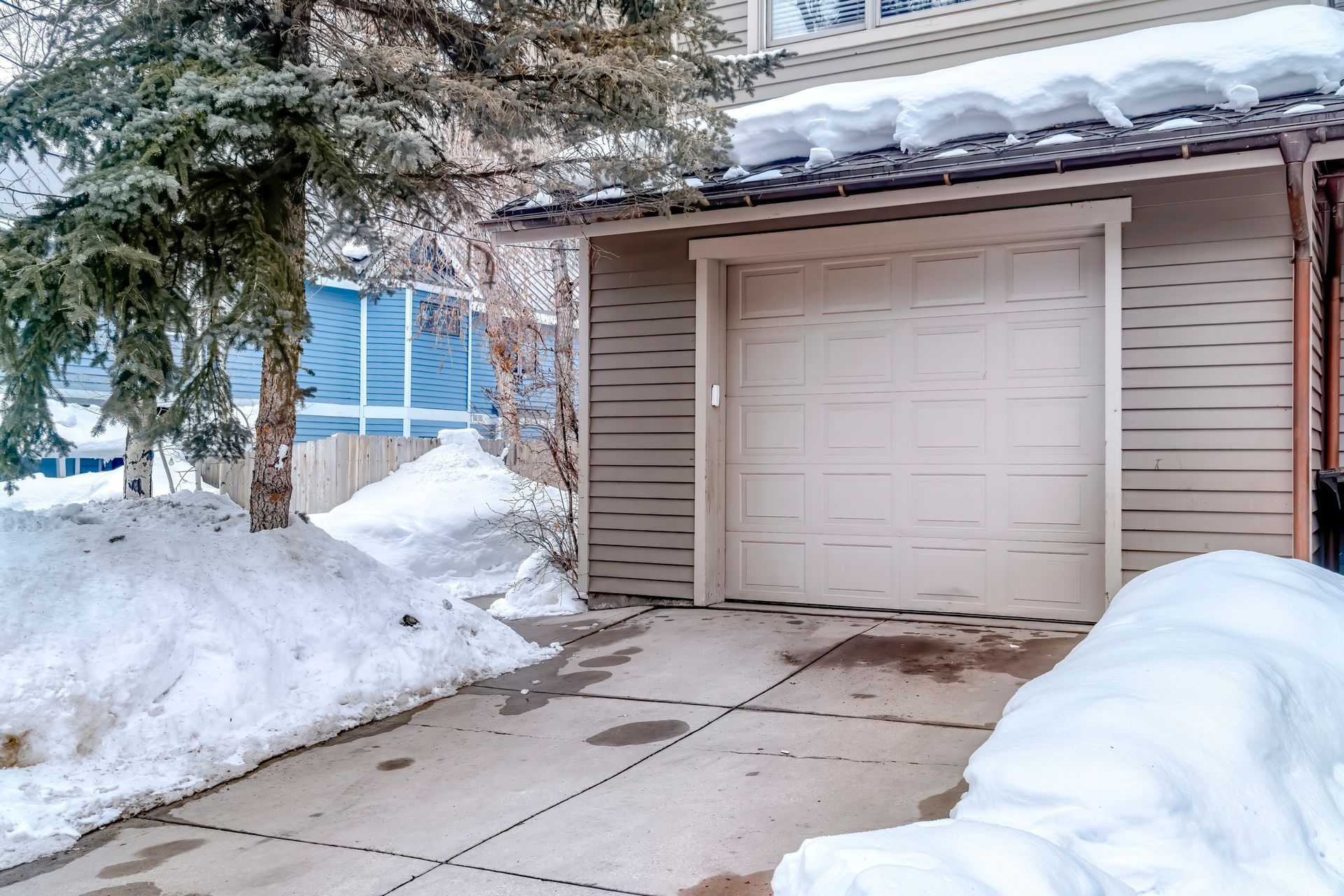 A garage door is open and covered in snow.