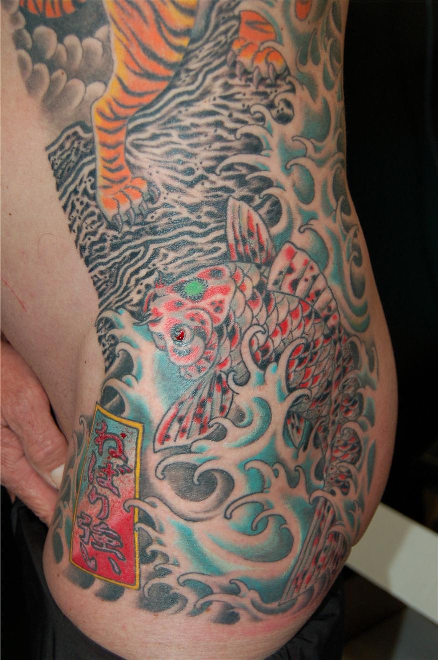 Koi fish tattoo below dragon fighting tiger tattoo — Little Rock, AR — Seventh Street Tattoos & Piercing