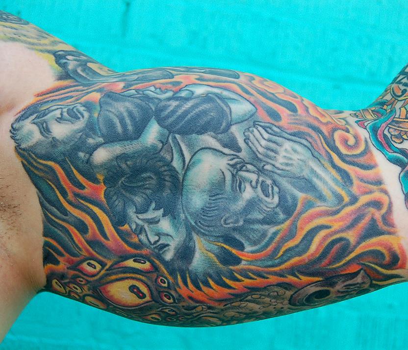 Persons burning in hell next to demonic eyes tattoo — Little Rock, AR — Seventh Street Tattoos & Piercing