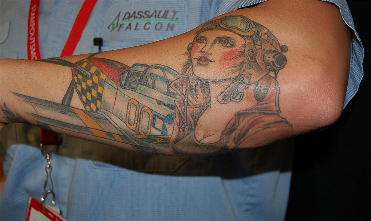 Female aviator in front of plane tattoo — Little Rock, AR — Seventh Street Tattoos & Piercing