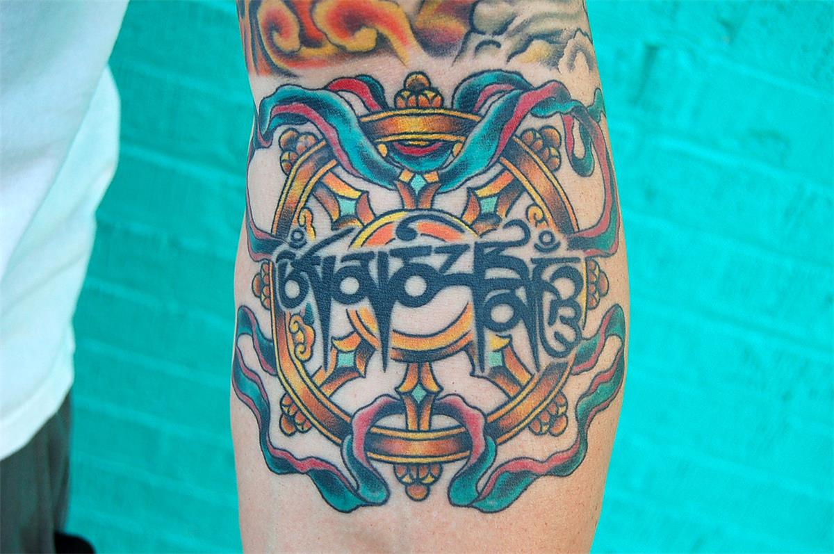 Gold circular object tattoo — Little Rock, AR — Seventh Street Tattoos & Piercing