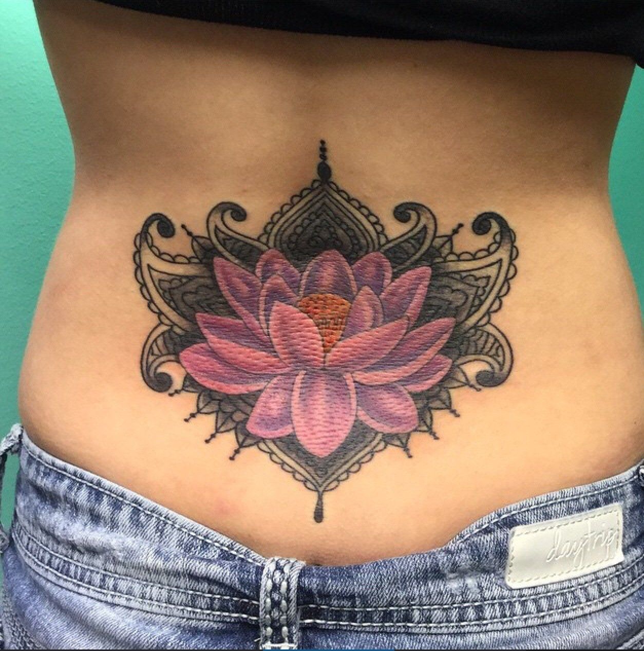 Purple flower at the back of a woman — Little Rock, AR — Seventh Street Tattoos & Piercing