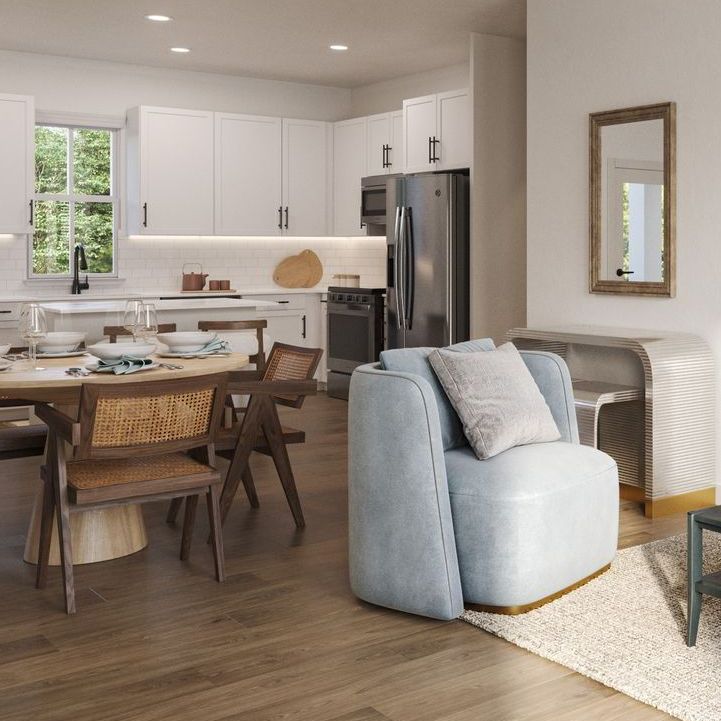 A living room with a table , chairs , and a refrigerator.